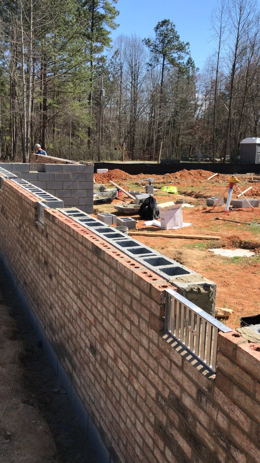 Brick wall under construction with extension ladders
