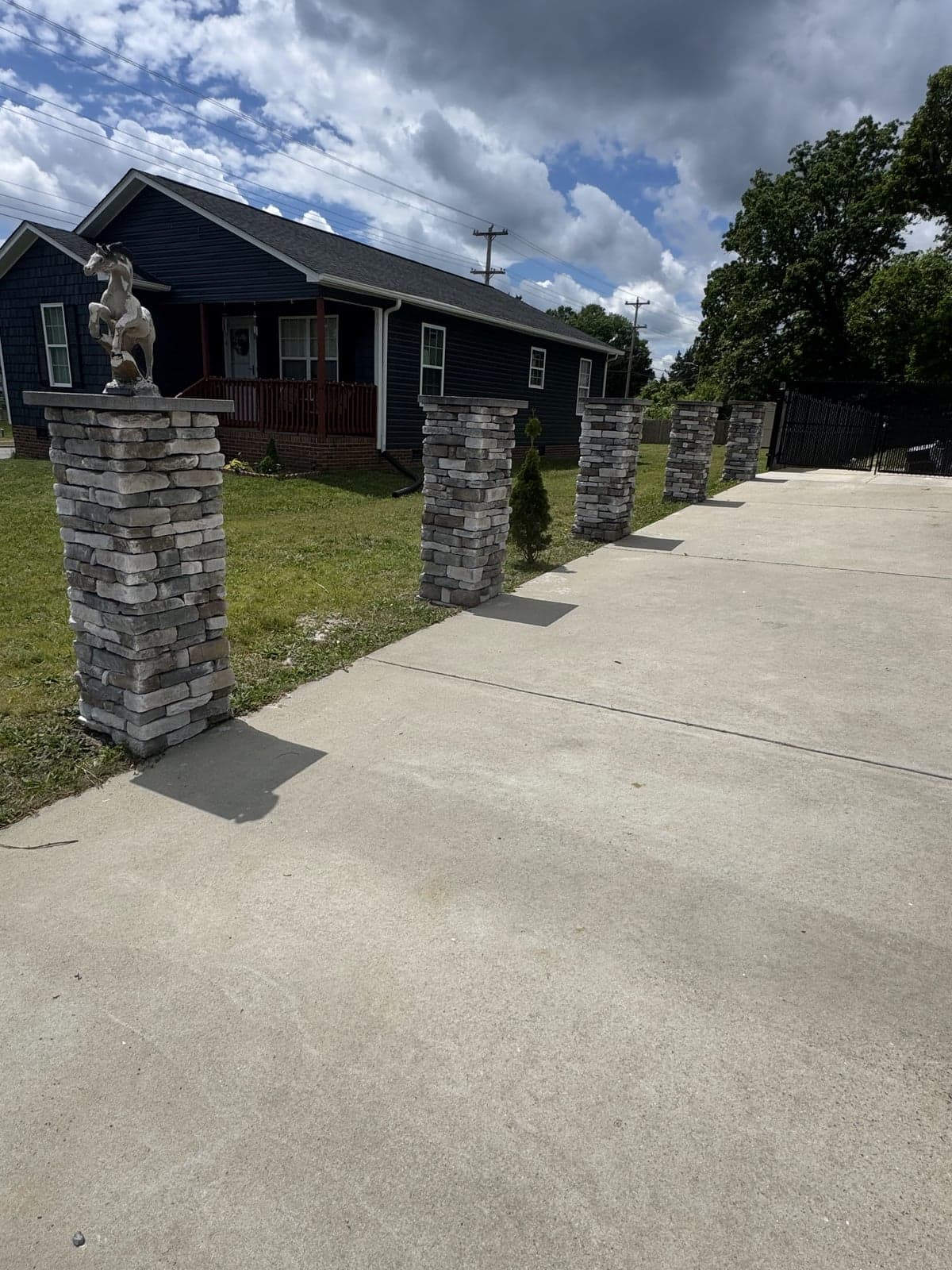 Stone driveway columns lining a paved drive