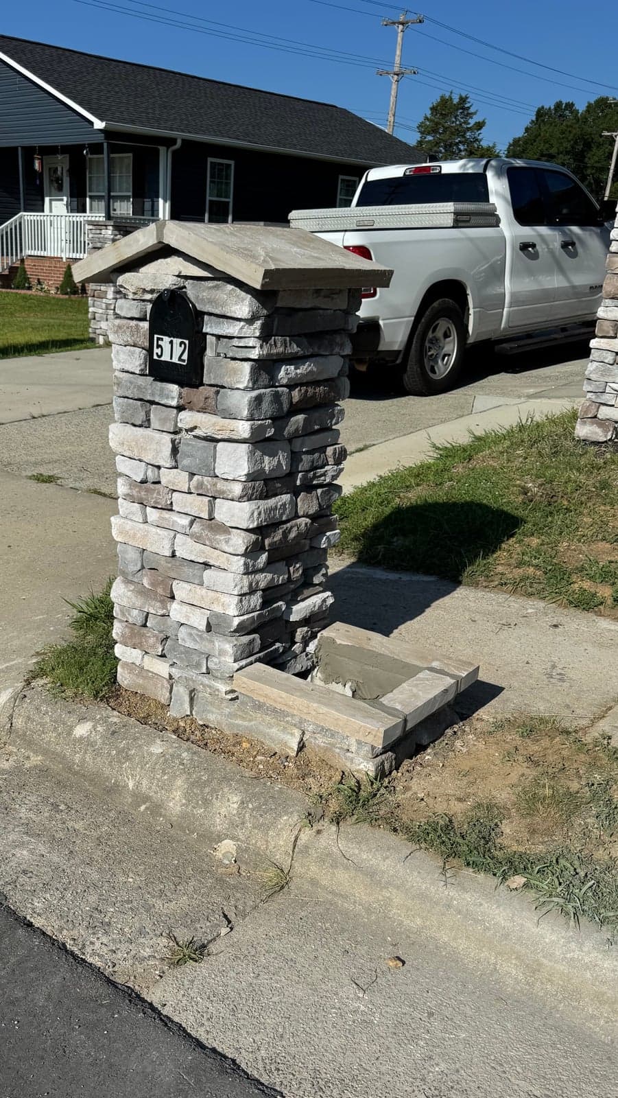 Stacked-stone mailbox with house number plaque